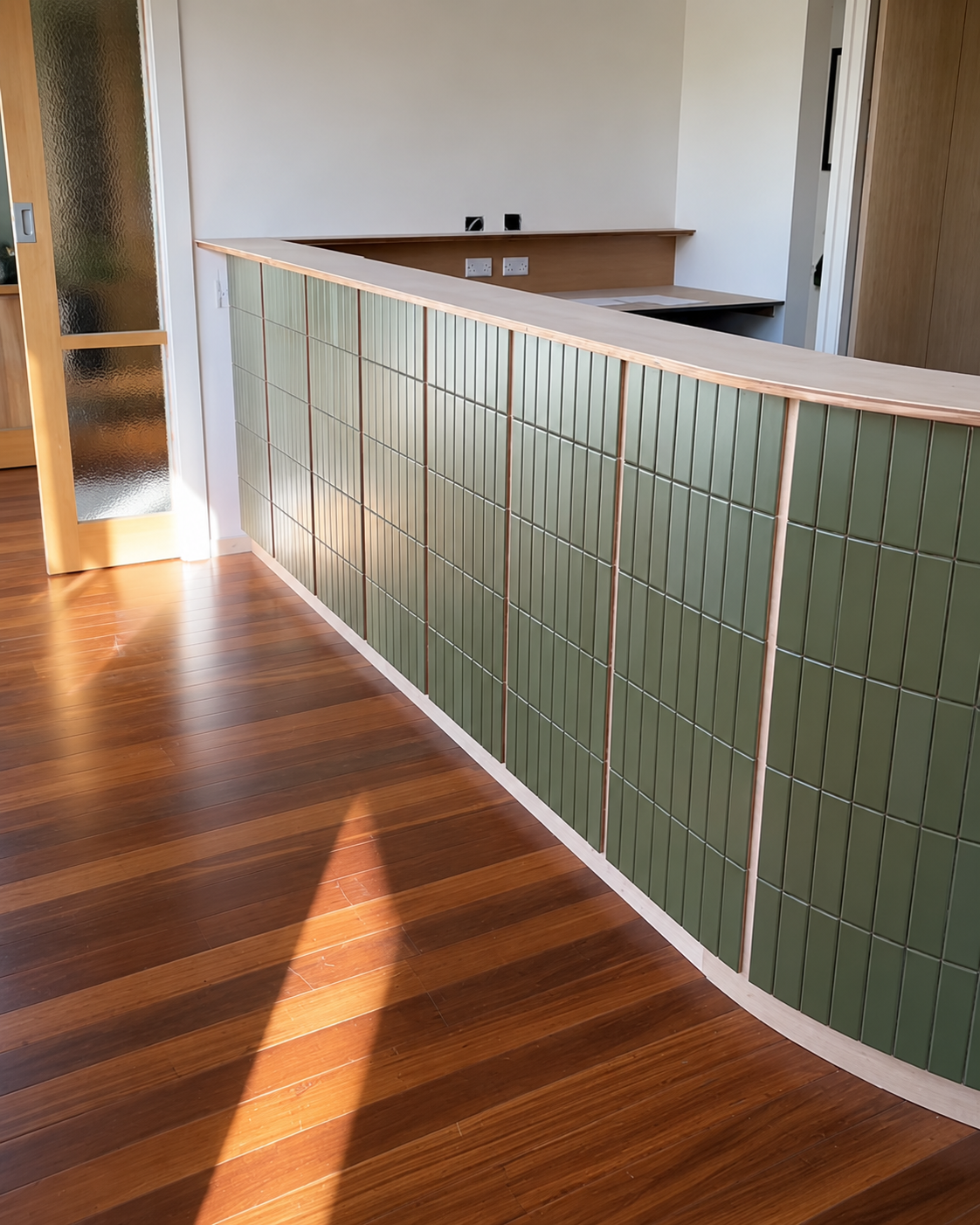 South Yarra residence with sage green vertical-stack finger tile on a curved partition wall